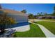 A beautifully landscaped yard with a charming home featuring well-maintained greenery, concrete driveway, and vibrant flowering tree at 14901 Wild Wood Lily Ct, Orlando, FL 32824
