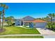 Beautiful single-Gathering home boasting a manicured lawn, well-kept landscaping, and a two-car garage, set against a clear blue sky at 14901 Wild Wood Lily Ct, Orlando, FL 32824