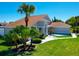 Well-maintained home featuring mature landscaping, lush green lawn, and a stylish architectural design under a clear blue sky at 14901 Wild Wood Lily Ct, Orlando, FL 32824