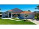 Well-maintained single-story home featuring a manicured lawn and bright, inviting entrance at 14901 Wild Wood Lily Ct, Orlando, FL 32824