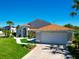 Spacious home showcasing a two-car garage, beautifully landscaped front yard, and a charming covered entrance at 14901 Wild Wood Lily Ct, Orlando, FL 32824