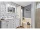 Bright bathroom featuring double sink vanity, tub and mosaic tile accent wall at 1562 Woodwind Dr, Apopka, FL 32703