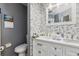 Bathroom featuring a double sink vanity with a mosaic tile accent wall and a modern toilet at 1562 Woodwind Dr, Apopka, FL 32703