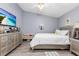 Large bedroom with a television, dresser, wooden floors, ceiling fan, and a modern silver bed frame at 1562 Woodwind Dr, Apopka, FL 32703