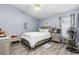 Cozy bedroom with wooden floors, ceiling fan, and a modern silver bed frame at 1562 Woodwind Dr, Apopka, FL 32703