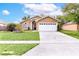 Charming single-story home featuring a well-maintained lawn and a two-car garage in a residential neighborhood at 1562 Woodwind Dr, Apopka, FL 32703