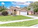 Charming single-story home featuring a well-maintained lawn and a two-car garage in a residential neighborhood at 1562 Woodwind Dr, Apopka, FL 32703