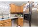 Well-lit kitchen featuring oak cabinets and stainless steel appliances at 1562 Woodwind Dr, Apopka, FL 32703