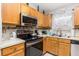Well-lit kitchen featuring oak cabinets and stainless steel appliances at 1562 Woodwind Dr, Apopka, FL 32703