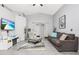 Inviting living room boasts vaulted ceilings, gray wood floors, and neutral, modern décor at 1562 Woodwind Dr, Apopka, FL 32703