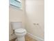 Well-lit bathroom features a standard toilet, a window, and neutral-colored walls and trim at 1686 Victoria Gardens Dr, Deland, FL 32724