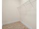 A simple walk-in closet with tile floor, white shelving and base trim ready for organizing at 1686 Victoria Gardens Dr, Deland, FL 32724