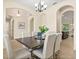 Elegant dining area featuring a modern chandelier, neutral tones, and seamless access to the living spaces and kitchen at 1686 Victoria Gardens Dr, Deland, FL 32724