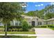 Charming single-story home with manicured landscaping, a brick driveway, and a neutral color palette under a blue sky at 1686 Victoria Gardens Dr, Deland, FL 32724