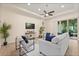 Cozy living room features stylish seating, a ceiling fan, and sliding glass doors providing access to the outdoor patio at 1686 Victoria Gardens Dr, Deland, FL 32724