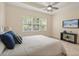 A comfy main bedroom has a ceiling fan and lots of natural light from the large windows overlooking the backyard at 1686 Victoria Gardens Dr, Deland, FL 32724