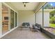Relaxing screened patio with comfortable seating, ceiling fan, and views of the landscaped backyard at 1686 Victoria Gardens Dr, Deland, FL 32724