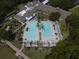 Aerial shot of a large community pool surrounded by palm trees, lounge chairs, and shaded pergolas at 1686 Victoria Gardens Dr, Deland, FL 32724
