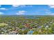 Panoramic aerial view of a lush, green residential neighborhood with lake views and tennis courts under a blue sky at 1701 Palmer Ave, Winter Park, FL 32789
