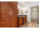 Bathroom features dual sinks, wood cabinets, dark countertops, and a closet at 1701 Palmer Ave, Winter Park, FL 32789