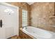 Bathroom featuring a soaking tub with tile surround and natural light at 1701 Palmer Ave, Winter Park, FL 32789
