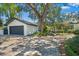 Charming home featuring a detached garage, lush landscaping, and a spacious driveway at 1701 Palmer Ave, Winter Park, FL 32789