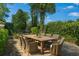 Charming outdoor dining area with a large wooden table and wicker chairs, surrounded by lush greenery at 1701 Palmer Ave, Winter Park, FL 32789