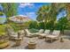 Inviting pool area with comfortable lounge chairs, lush landscaping, and an umbrella for shade at 1701 Palmer Ave, Winter Park, FL 32789