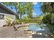 Backyard pool showcasing lush greenery, stone coping and brick paver patio at 1701 Palmer Ave, Winter Park, FL 32789