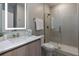 Contemporary bathroom with a floating vanity, backlit mirror, and a glass-enclosed shower, offering a spa-like experience at 17522 Hidden Forest Dr, Clermont, FL 34714