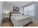 Comfortable bedroom features neutral tones, with a stylish wall art piece, and natural light streaming through sheer curtains at 17522 Hidden Forest Dr, Clermont, FL 34714