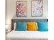 A cozy bedroom arrangement shows bright accent pillows and art displayed above a gray cushioned headboard at 17522 Hidden Forest Dr, Clermont, FL 34714