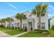 Modern two-story townhomes boasting pristine landscaping, stone accents, and decorative palm trees lining the sidewalk at 17522 Hidden Forest Dr, Clermont, FL 34714