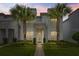 Beautiful two-story home featuring stone accents, well-manicured lawn, and decorative palm trees against an evening sky at 17522 Hidden Forest Dr, Clermont, FL 34714