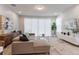 Bright living room features a plush sectional sofa, modern decor, and sliding doors to the outdoor space at 17522 Hidden Forest Dr, Clermont, FL 34714