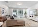 Bright living room features a plush sectional sofa, modern decor, and sliding doors to the outdoor space at 17522 Hidden Forest Dr, Clermont, FL 34714