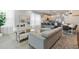 Open-concept living space with a sleek sectional sofa, modern kitchen, and dining area for seamless entertaining at 17522 Hidden Forest Dr, Clermont, FL 34714