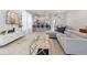Open-concept living space with a sleek sectional sofa, modern kitchen, and dining area for seamless entertaining at 17522 Hidden Forest Dr, Clermont, FL 34714