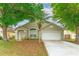 Charming single-story home featuring a well-manicured lawn, mature trees, and a two-car garage at 2104 Remington Pointe Blvd, Kissimmee, FL 34743