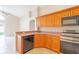 Modern kitchen showcasing stainless steel appliances, ample wood cabinetry, and a breakfast bar at 2104 Remington Pointe Blvd, Kissimmee, FL 34743