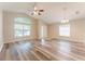 Spacious living area featuring wood floors, ceiling fan, and ample natural light from multiple windows at 2104 Remington Pointe Blvd, Kissimmee, FL 34743