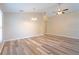 Open-concept living room with wood floors, ceiling fan, neutral walls, and seamless flow into other areas at 2104 Remington Pointe Blvd, Kissimmee, FL 34743