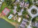 Overhead shot of community amenities including a tennis court, pool, playground, and lush landscaping near residential streets at 218 Castlemain Cir, Davenport, FL 33897