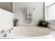 Close-up on a soaking tub with a large window and decorative towels in the bathroom at 218 Castlemain Cir, Davenport, FL 33897