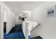 Bright hallway featuring blue carpet, neutral walls, and decor, leading to various rooms in the home at 218 Castlemain Cir, Davenport, FL 33897