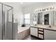 Well-lit main bathroom with a shower, soaking tub, dual vanity and a large mirror at 218 Castlemain Cir, Davenport, FL 33897