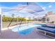 Relaxing screened-in pool area with outdoor seating, surrounded by lush landscaping and clear blue skies at 218 Castlemain Cir, Davenport, FL 33897