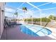 Relaxing screened-in pool area with lounge chairs, surrounded by lush landscaping and clear blue skies at 218 Castlemain Cir, Davenport, FL 33897
