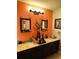 Bathroom featuring double sinks, a dark wood vanity, large mirrors, and a stylish lighting fixture at 2285 Seven Oaks Dr, St Cloud, FL 34772