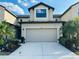 Charming townhome with a two-car garage, beautiful landscaping, and a well-lit driveway on a sunny day at 2285 Seven Oaks Dr, St Cloud, FL 34772